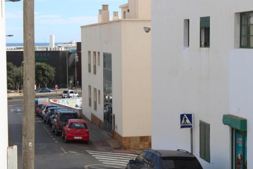 a row of cars parked on a street next to a building at Piso de 2 habitaciones en Arrecife in Arrecife