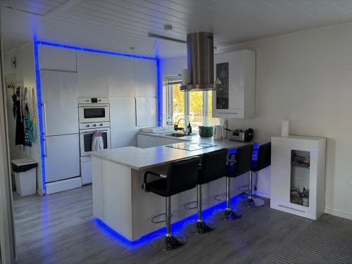 a kitchen with blue lights on a white counter top at Spacious & Cozy home with open kitchen lounge in Søborg