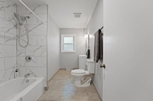 a bathroom with a tub and a toilet and a shower at Exceptional Willowbrook Retreat in Willowbrook