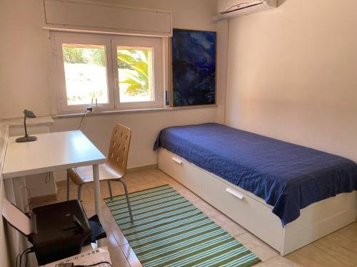 een slaapkamer met een bed, een bureau en een tafel bij La Casa dell'Aviatore in Boccadifalco