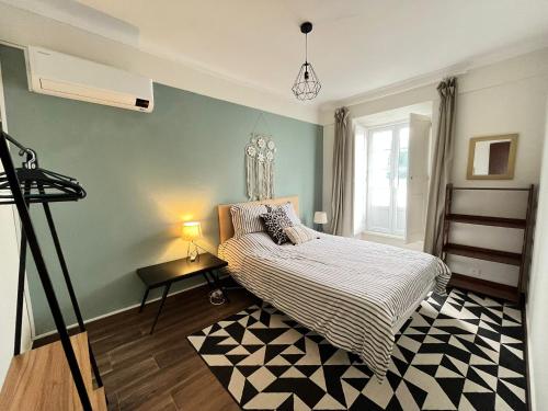 a bedroom with a bed and a table with a lamp at Casa Três Campos, Povoação in Povoação