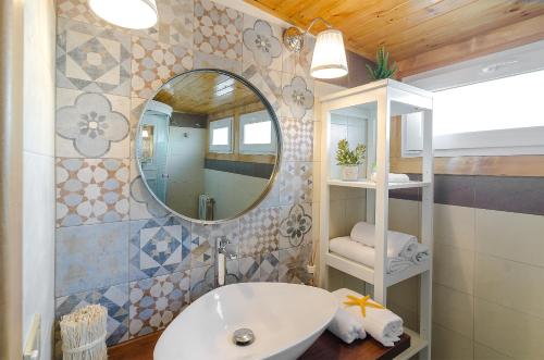 a bathroom with a sink and a mirror at Casa delle Zammare Fronte mare centro storico in Riposto