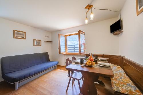 a living room with a blue couch and a table at Miramonti 21 Ski In - Ski Out - Happy Rentals in Sauze dʼOulx