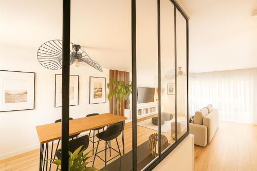 een eetkamer en een woonkamer met een glazen wand bij L'Echappée REmily - La Rochelle - proche Ile de Ré in La Rochelle