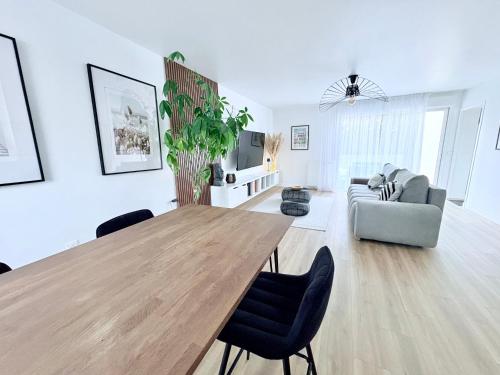 een woonkamer met een houten tafel en een bank bij L'Echappée REmily - La Rochelle - proche Ile de Ré in La Rochelle