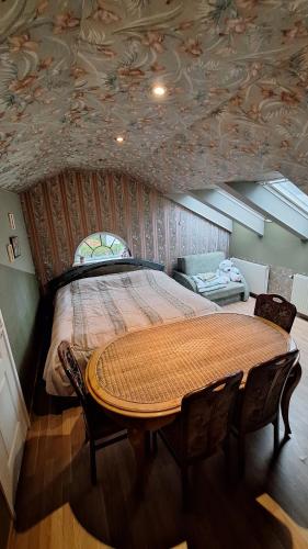 a bedroom with a large bed and a table at Guest House Krista in Jūrmala