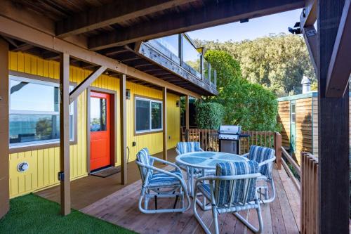 a patio with a table and chairs on a deck at Small Home with Ocean View walk to Restaurants Brewery Shops Beach in Pacifica