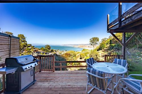 a deck with a grill and a table and chairs at Small Home with Ocean View walk to Restaurants Brewery Shops Beach in Pacifica