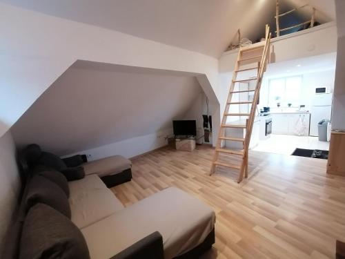 a living room with a ladder and a couch at Appartement in Kesseldorf