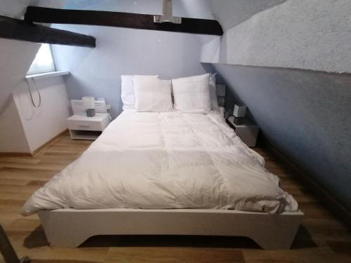a bedroom with a bed with white sheets and pillows at Appartement T2 44 m2 in Kesseldorf