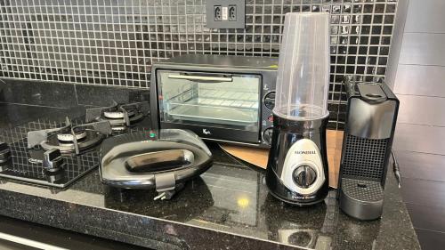 Il comprend une cuisine équipée d'un four micro-ondes, d'un grille-pain et d'un grille-pain. dans l'établissement Chalé com banheira, piscina e cachoeira privativa, à Taubaté