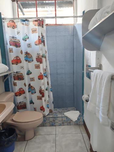 a bathroom with a shower curtain with cars on it at El Aguacatal in Panajachel