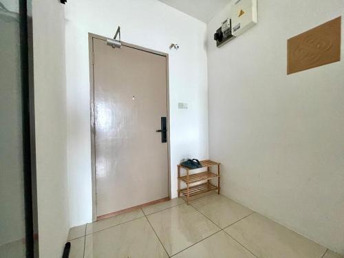 een deur in een witte kamer met een tafel ernaast bij SamStudio in Penampang