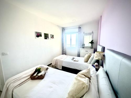 a room with two beds and a couch in it at Costamar Infinite Sea Views by Deihu Experiences in Los Cristianos