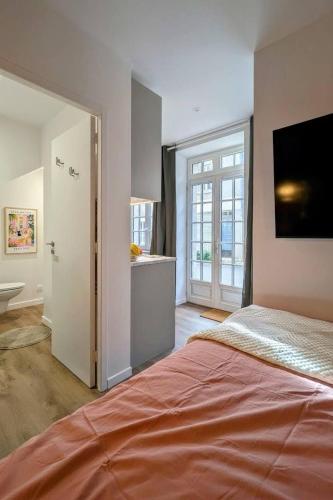a bedroom with a large bed and a bathroom at Studio cosy proche étang et commerces in Saint-Aubin-du-Cormier