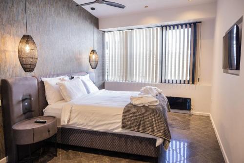 a bedroom with a large bed and a window at Trikala mall suites in Tríkala