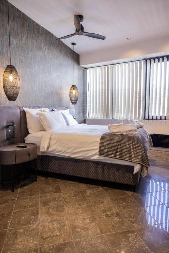 a bedroom with a large bed and a ceiling fan at Trikala mall suites in Tríkala