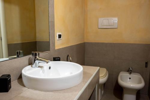 a bathroom with a white sink and a toilet at Piacenza centro in Piacenza