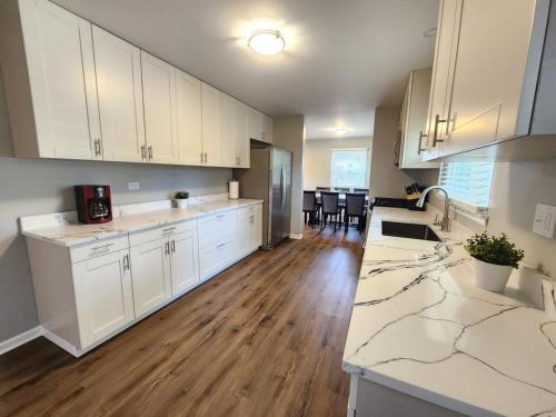 eine Küche mit weißen Schränken und einer Arbeitsplatte in der Unterkunft Naperville Gem in Naperville