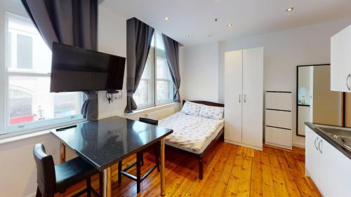 a living room with a table and a couch at Comfortable Studio in City Centre Nottingham in Nottingham