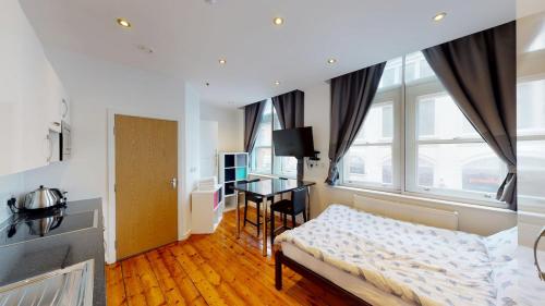 a bedroom with a bed and a desk in a room at Comfortable Studio in City Centre Nottingham in Nottingham