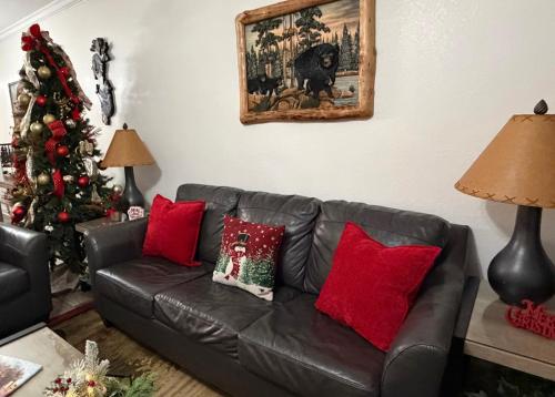 a living room with a leather couch and a christmas tree at A Beary Good Getaway condo in Pigeon Forge