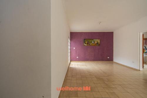 Ein leerer Raum mit Fliesenboden und lila Wand in der Unterkunft Casa no Centro de Peruibe a 750m da Praia in Peruíbe