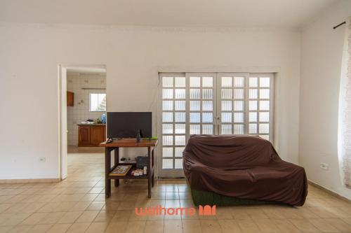 ein Wohnzimmer mit einem Stuhl und einem Tisch in der Unterkunft Casa no Centro de Peruibe a 750m da Praia in Peruíbe