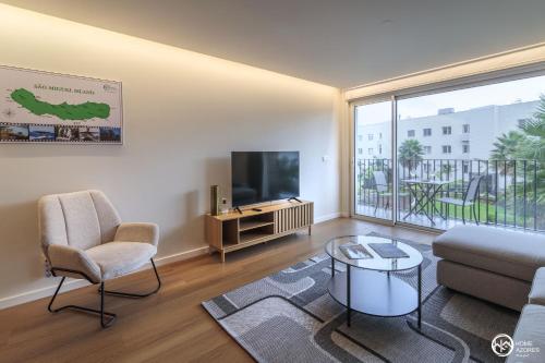 a living room with a couch and a tv at Home Azores - Coliseu Residences in Ponta Delgada