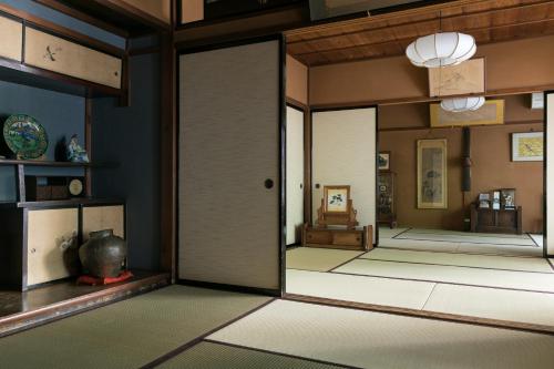 a room with an open door and a room with mats at Sumiyoshi Ryokan in Takayama