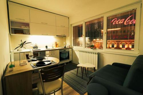 eine Küche mit einer Couch und einem Tisch in einem Zimmer in der Unterkunft The Place in Skopje
