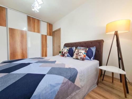 ein Schlafzimmer mit einem Bett und einer Lampe in der Unterkunft The Place in Skopje