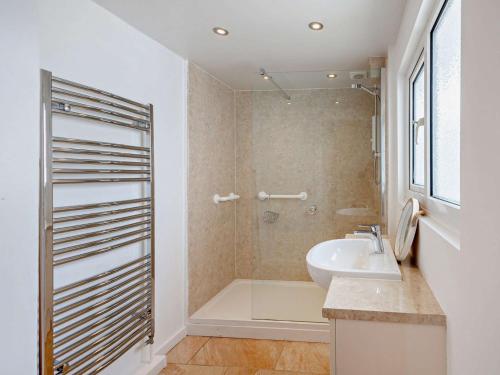 a bathroom with a tub and a sink and a shower at 4 Bed in Beaumaris 94501 in Llanddona