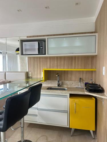 a kitchen with a sink and a microwave at Apart estiloso! in Feira de Santana