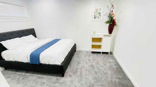a bedroom with a bed and a night stand with a vase at Ivey Homes in Edmonton