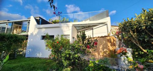 una casa blanca con flores y plantas en Casas Floeca, en Jardim do Mar