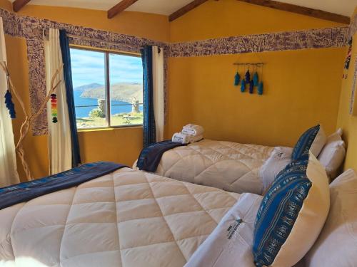 ein Schlafzimmer mit zwei Betten und einem Fenster in der Unterkunft Kalluchi Ecolodge-Sun Island Titicaca Lake BOLIVIA in Comunidad Yumani