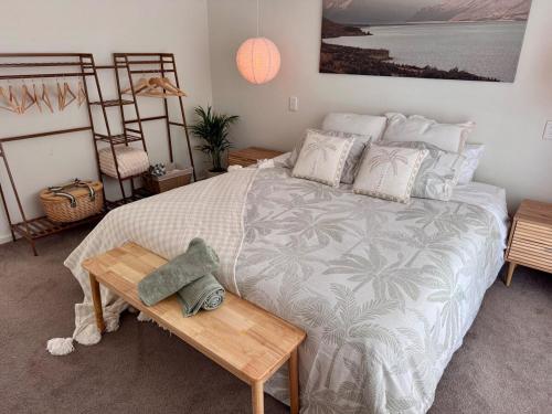 Schlafzimmer mit einem großen Bett und einem Holztisch in der Unterkunft Walk to Beach - Coastal Beach House Retreat in Port Willunga