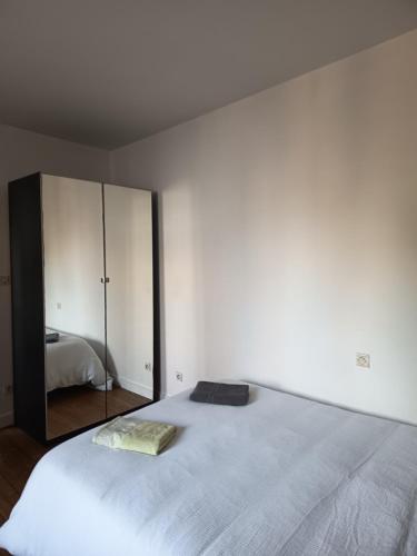 a bedroom with a large bed and a mirror at Le studio du cinéma in Évron