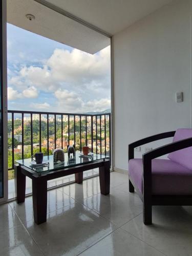 un salon avec une table et une grande fenêtre dans l'établissement Apartamento Bucaramanga, à Bucaramanga