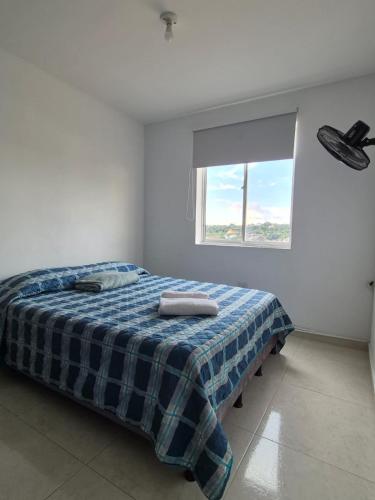 - une chambre dotée d'un lit avec une couverture bleue dans l'établissement Apartamento Bucaramanga, à Bucaramanga