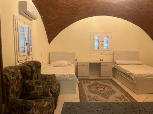 a room with two beds and a couch and windows at Mountain Camp Ali Khaled in Siwa