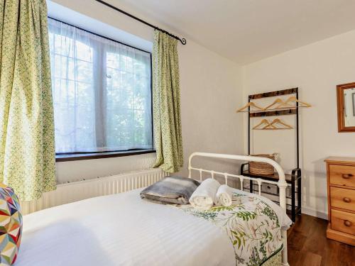 a bedroom with a white bed and a window at 2 Bed in Minehead 90925 in Minehead