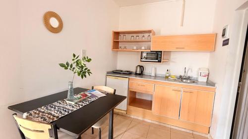 a small kitchen with a table and a small kitchen with a table and chairs at G8 Hermoso Monoambiente con Cochera 2 huéspedes in Villa Ángela
