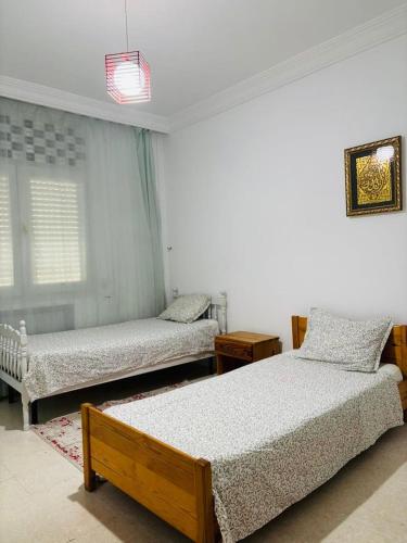 a bedroom with two beds and a window at Dream Appartement Monastir in Monastir