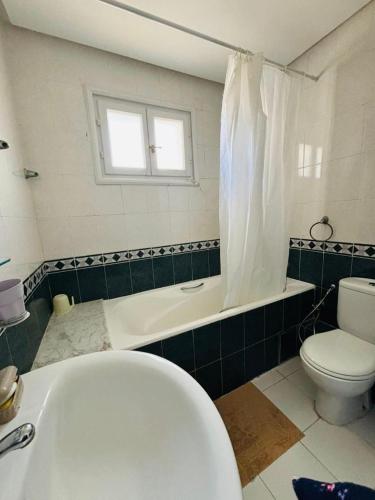 a bathroom with a bath tub and a toilet at Dream Appartement Monastir in Monastir