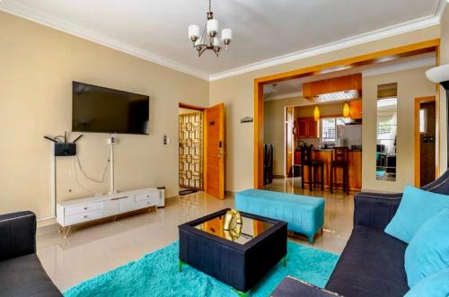 a living room with a couch and a tv at Sky Blue in Jarabacoa