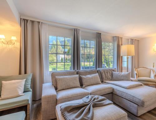 a living room with a couch and some windows at Mountain Residence in Kandersteg