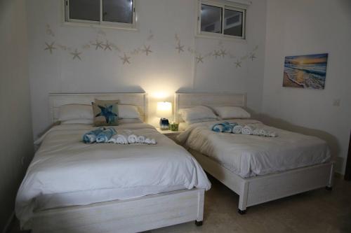 two beds sitting next to each other in a bedroom at Ocean Bliss: Balcony & Pools & Peloton Bike! in Lowlands