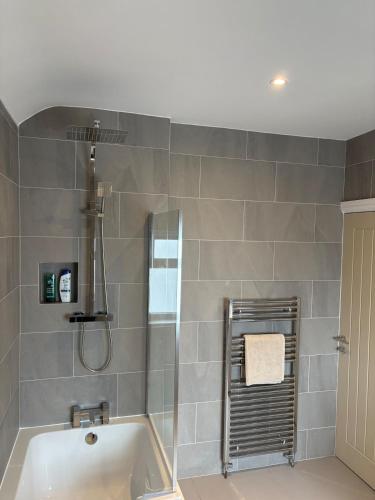 a bathroom with a shower and a bath tub at Luxury Four Bedroom House in Rock Ferry